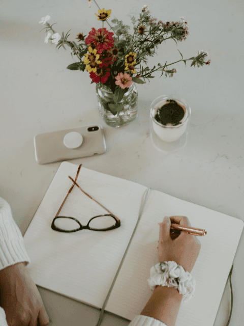 Writing in notebook on desk