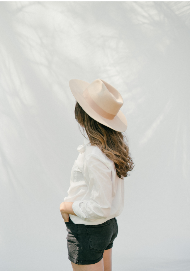 Emily in hat on white fabric background